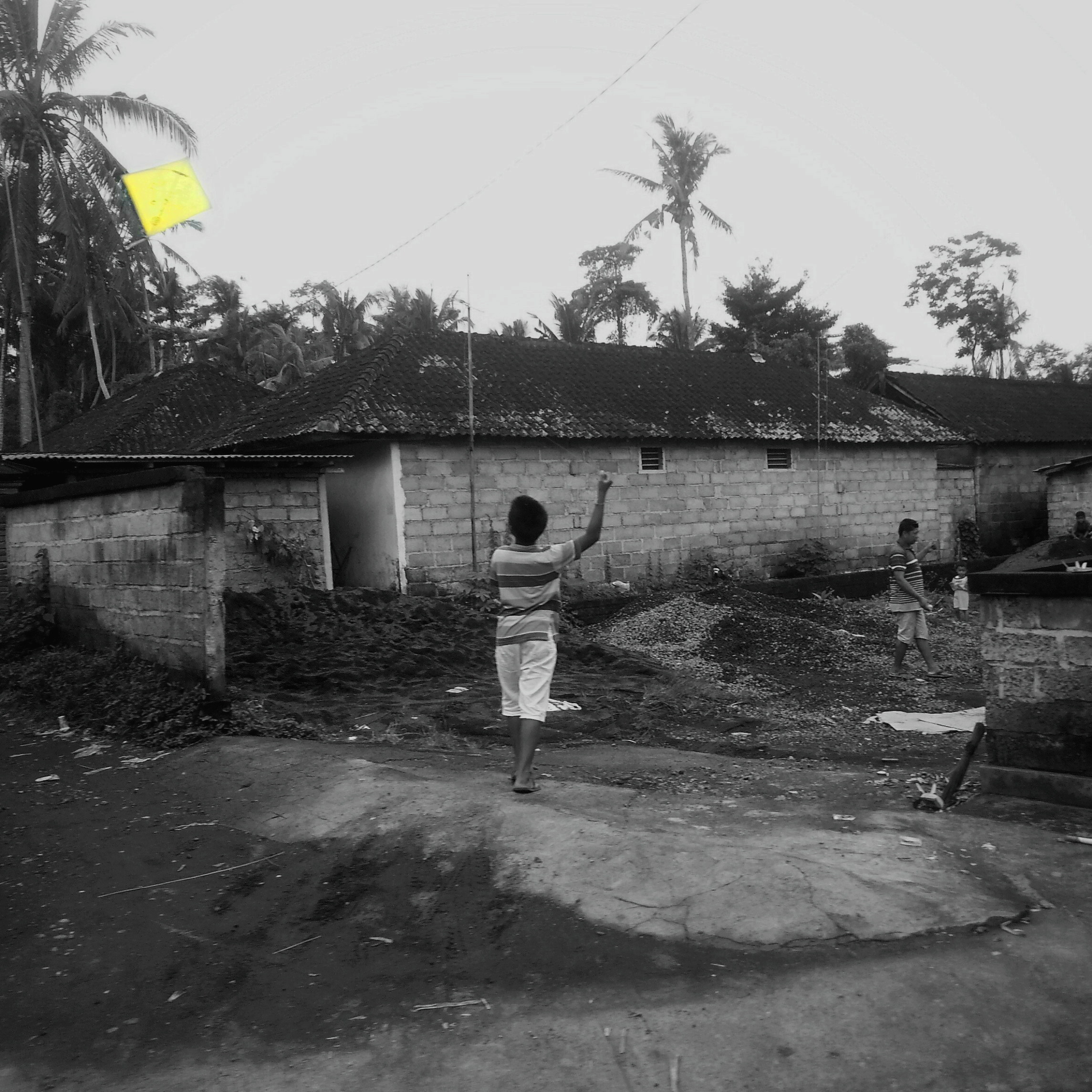 A kid playing with a kite near the market