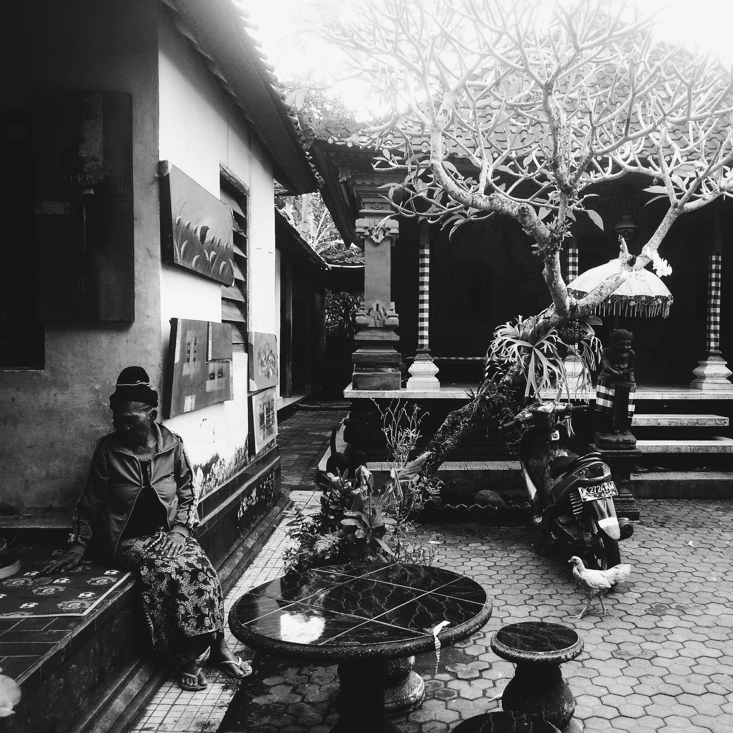 An elderly woman takes a break outside the market